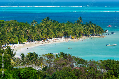 Landscape of the beach of San Andres island and Providencia Archipelago in Colombia with blue ocean and green palms and vegetation with boats and tourists  