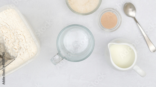 Dry yeast, milk, sugar, flour. Close up baking process, ingredients for baking needs on kitchen table