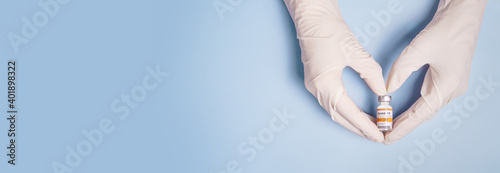 Doctor Hands in protective gloves holding Coronavirus 2019-nCoV Vaccine vial and gesture in heart shape Fototapete