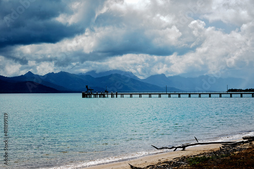 Storm clouds over Hinchinbrook Island and Cardwell jetty located on the Cassowary Coast in Far North Queensland Australia photo
