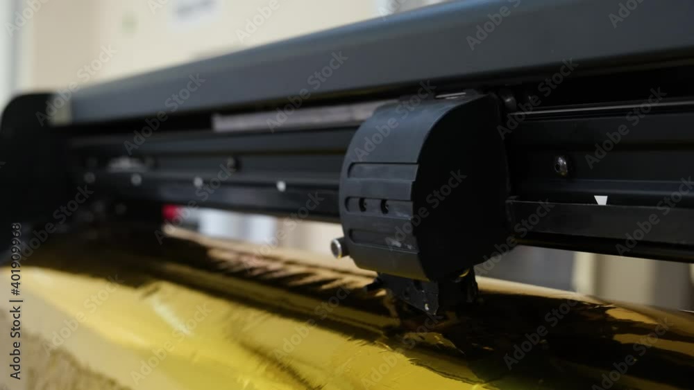 Golden foil cutting plotter machine. Vinyl cutter plotter machine and moving cutting head. Golden foil cutting plotter machine. Vinyl cutter plotter machine and moving cutting head.