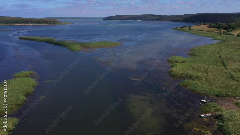 A panoramic shot from Durugol Turkey. There is a lake near a path filled with forest and green grass under the blue sky. A panoramic shot from Durugol Turkey. There is a lake near a path filled with forest and green grass under the blue sky.