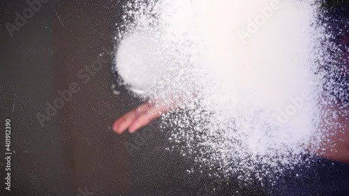 Sifting flour through a sieve onto a glass surface. Bottom view.