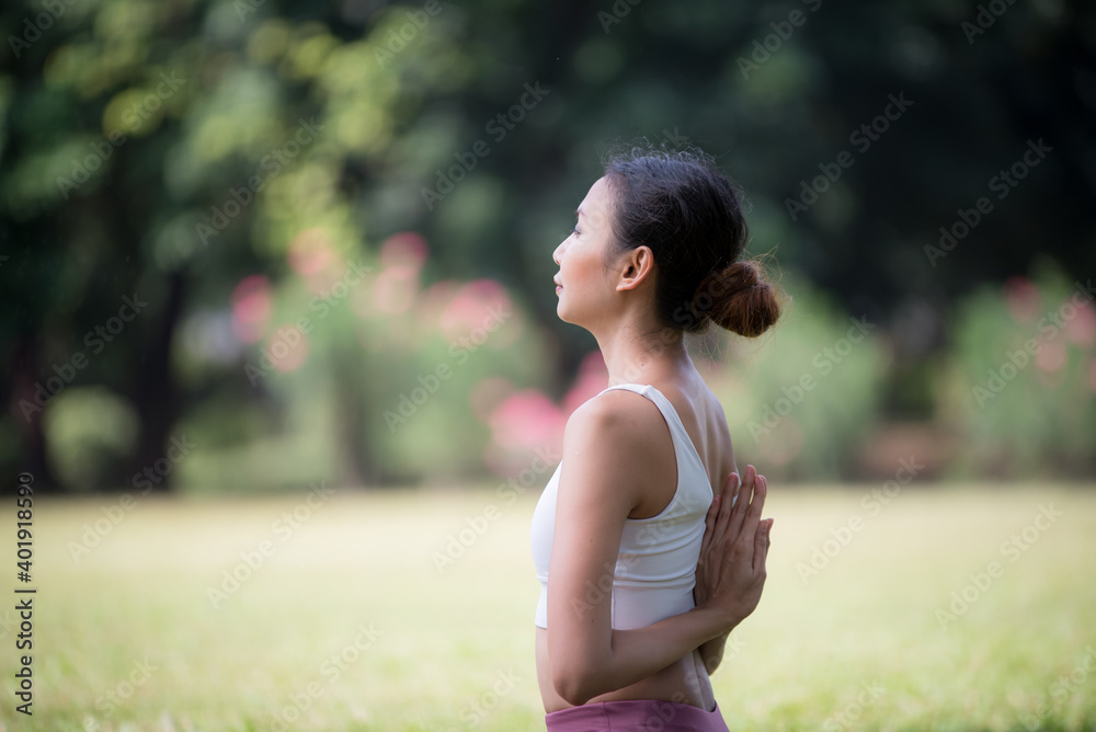 Asian model poses yoga in a park on a natural green background, health care concept, beautiful body structure, fit body Asian model poses yoga in a park on a natural green background, health care concept, beautiful body structure, fit body