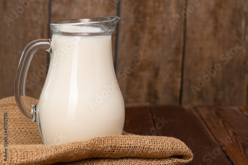 Glass jar of milk on old wooden table