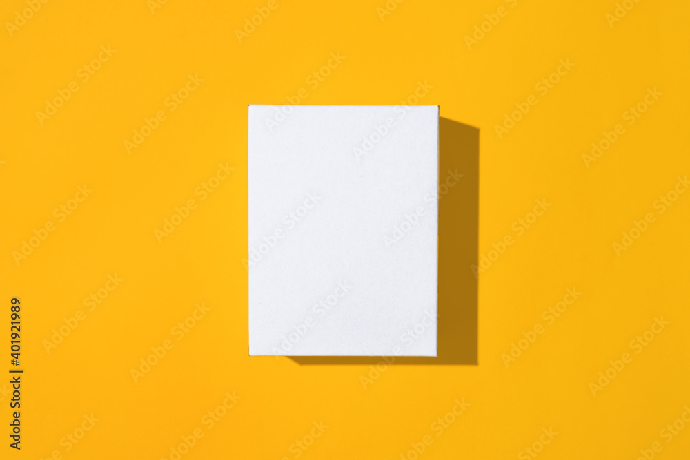 White empty small box mockup on yellow background top view. White empty small box mockup on yellow background top view.