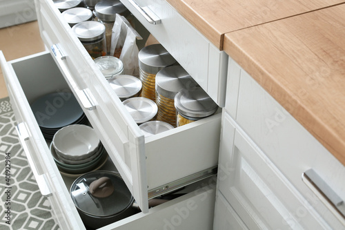 Glass jars with products and utensils in drawers