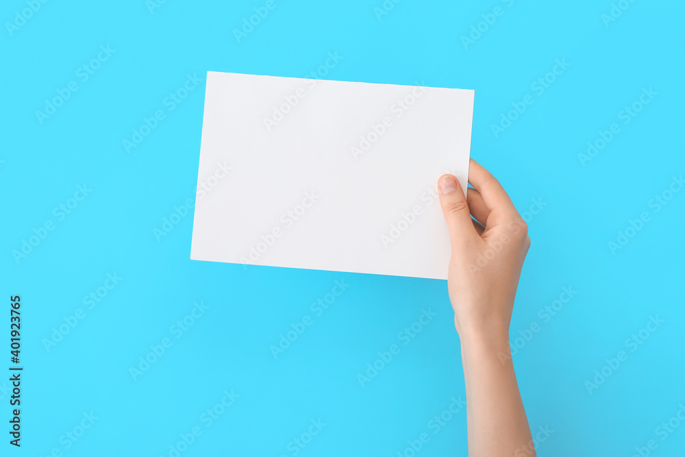Fototapeta premium Female hand with blank paper on color background