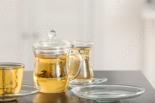 Cups of green tea and teapot on table