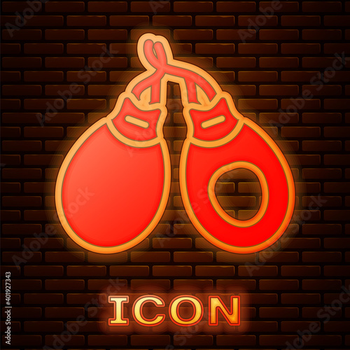 Glowing neon Musical instrument castanets icon isolated on brick wall background. Vector.