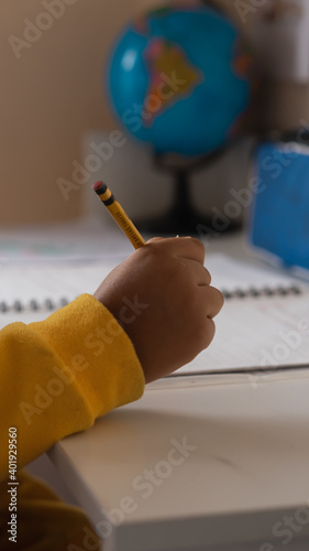 A vrtical shot of a child studying at home photo