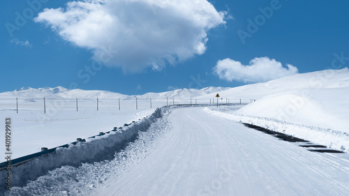 Road with snow, blue sky and white clouds in Tibet,West of China.
