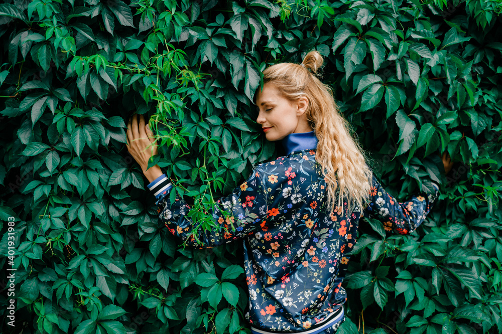 Beautiful stylish blonde model posing in green bushes Beautiful stylish blonde model posing in green bushes