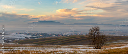 Beautiful landscape of Slovakia - undulating fields  mountains  blown by snow  shrouded in morning mist