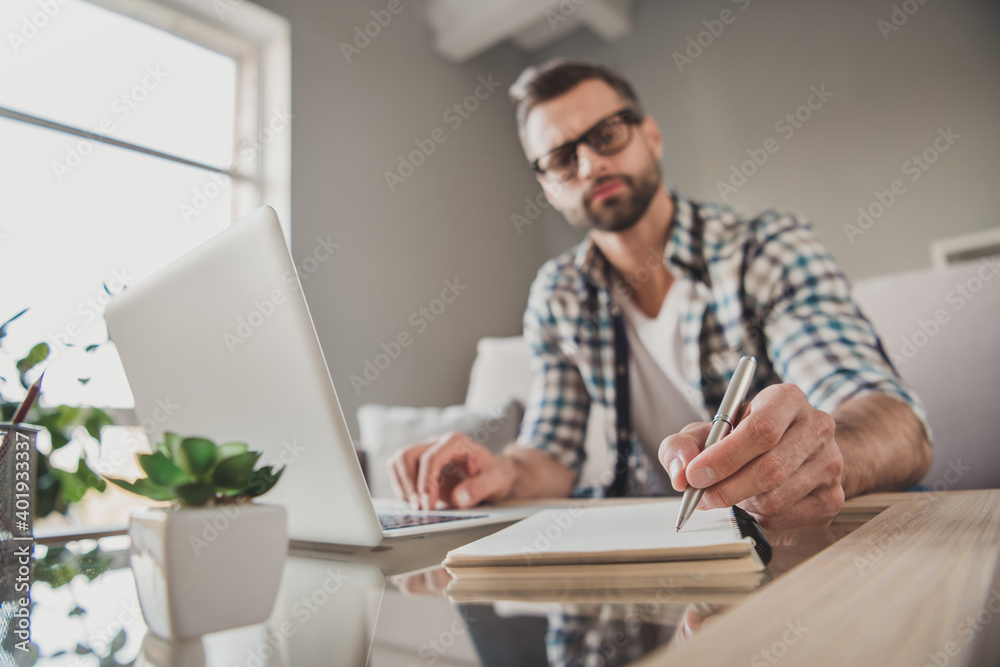Photo of young handsome man remote work watch seminar write notebook plan to-do list serious sit couch indoors