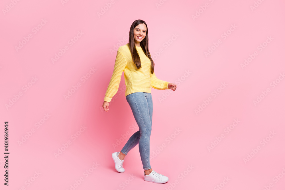 Full size profile side photo of young beautiful attractive smiling positive girl go walk take step isolated on pink color background Full size profile side photo of young beautiful attractive smiling positive girl go walk take step isolated on pink color background