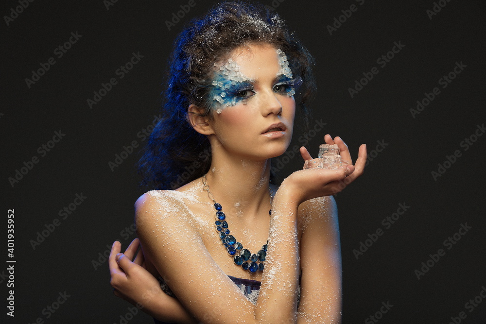 Obraz premium portrait of a beautiful girl with a fantasy winter makeup with ice pieces in her hands