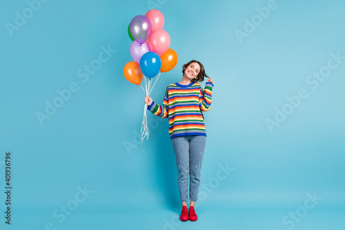 Full length body size view of cute modest cheerful girl holding in hand air balls isolated over bright blue color background