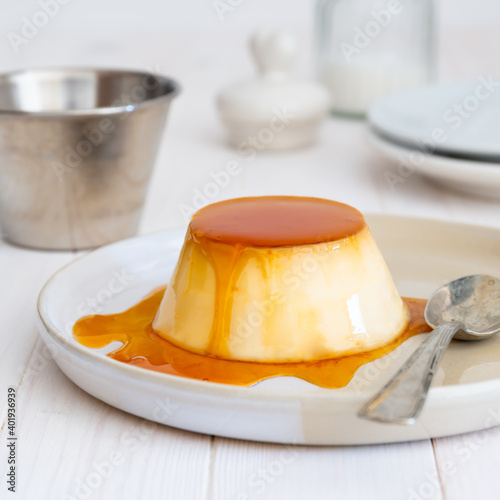 Bild auf Leinwand Egg custard in plate with spoon on white background