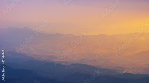 Landscape wide view sunrise or sunset of of mountains in misty day.