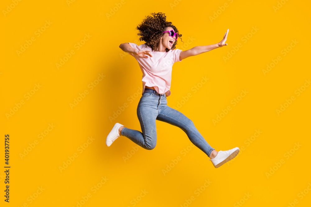 Photo portrait full body view of woman kicking jumping up isolated on vivid yellow colored background