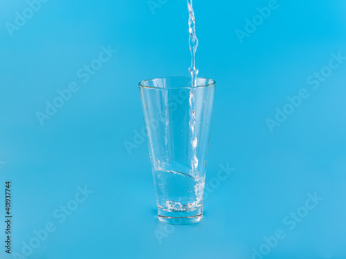 Glass with water aqua on blue background