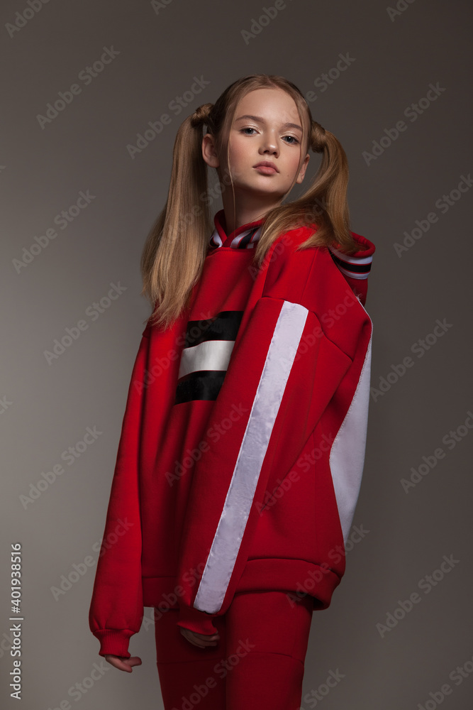 beautiful teen girl in a red tracksuit with white stripes