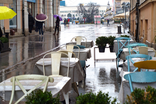 Rainy weather and wet dining tables on the outdoor terrace of cafe in Novi Sad, Serbia