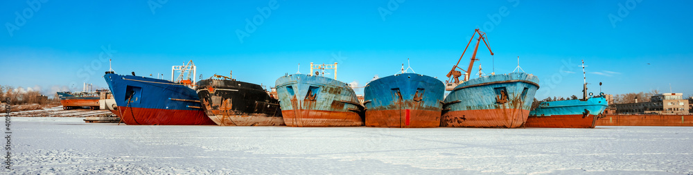 Togliatti, Russia - 25 Dec 2020: Ship repair plant, old abandoned ships for oil extraction in winter snowy landscape, frozen river