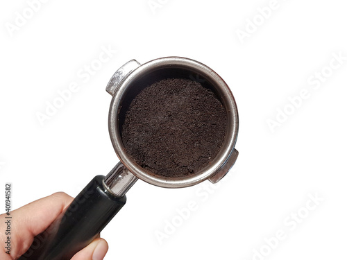 Close up wet coffee grounds in portafilter in barista hand isolated on white background.