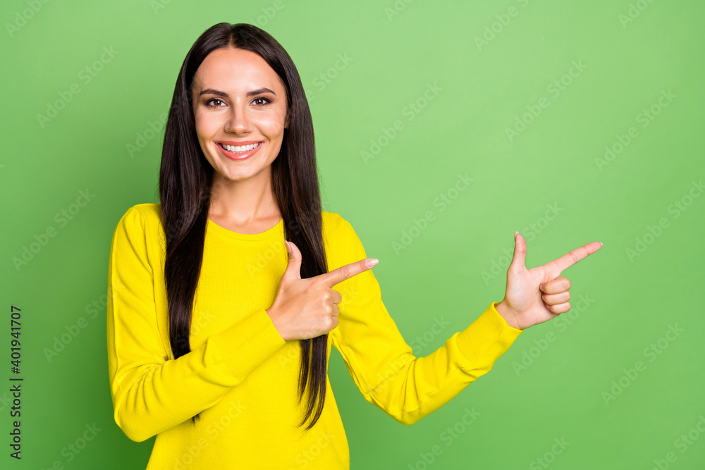 Portrait of cheerful lady toothy smile indicate two hands fingers empty space isolated on green color background Portrait of cheerful lady toothy smile indicate two hands fingers empty space isolated on green color background
