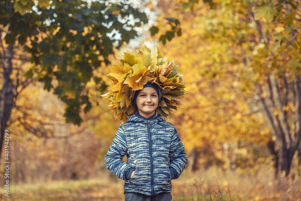 little boy in the autumn forest wearing a wreath of yellow leaves little boy in the autumn forest wearing a wreath of yellow leaves