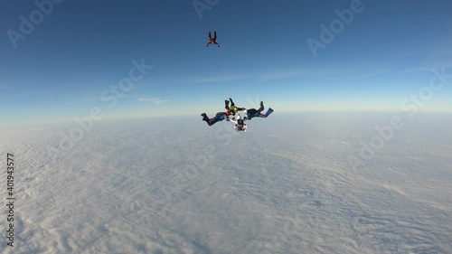 Skydiving. Team jump. Skydivers are doing figures in the sky.