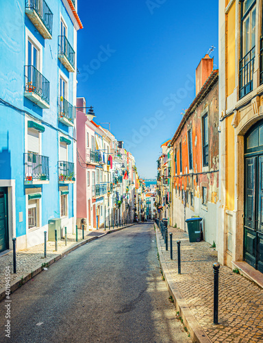 Typical narrow street with colorful multicolored traditional buildings and houses in Lisbon Lisboa historical city centre, Portugal.