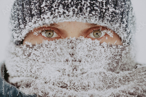 Close up portrait of a man from Siberia. The man's face is wrapped in a scarf and covered with snow. A man in sub-zero weather.