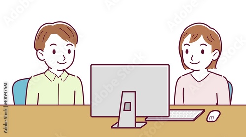Two people talking while looking at a desktop computer
