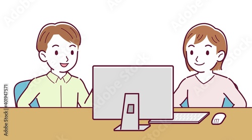 Two people talking while looking at a desktop computer