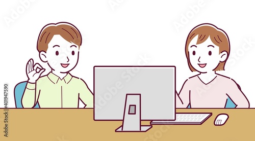 Two people talking while looking at a desktop computer