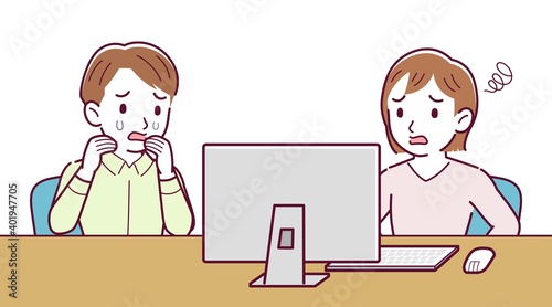 Two people talking while looking at a desktop computer