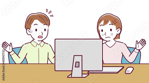 Two people talking while looking at a desktop computer