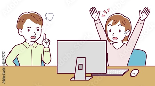 Two people talking while looking at a desktop computer