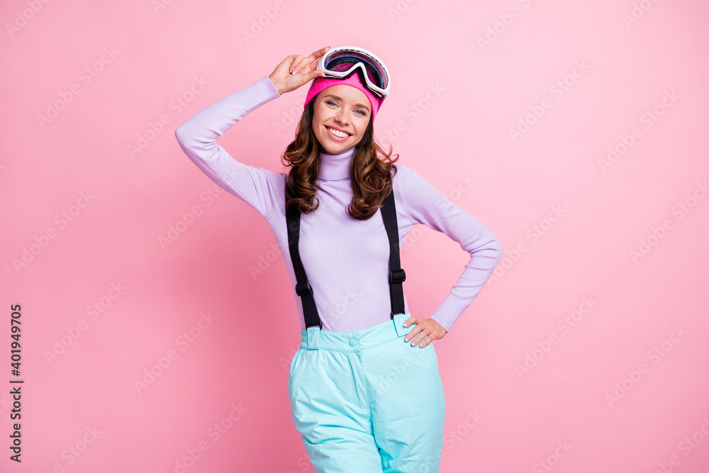 Photo of pretty lady snowboarder wear purple pullover headwear arm mask glasses waist relaxing isolated pink color background