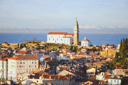 Red roofs of the historical center of old town Piran with main church against the sunset sky and Adriatic sea. Aerial view, Slovenia