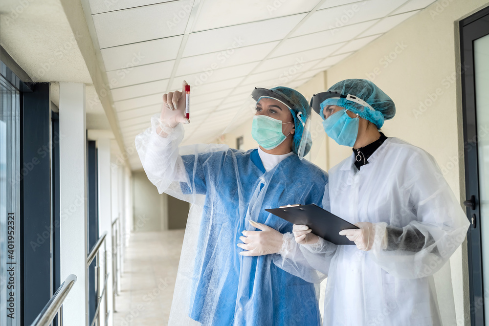 Naklejka premium Work in the clinic. Healthcare workers with test tubes with blood record the result of the test
