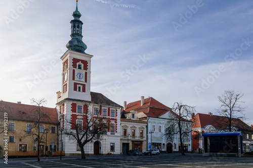 Old Town Hall with Clock Tower at the main Masaryk square of historic medieval royal town Slany, colorful renaissance houses in sunny winter day, Central Bohemia, Czech Republic