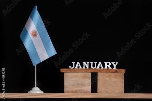 Wooden calendar of January with Argentine flag on black background. Holidays of Argentina in January