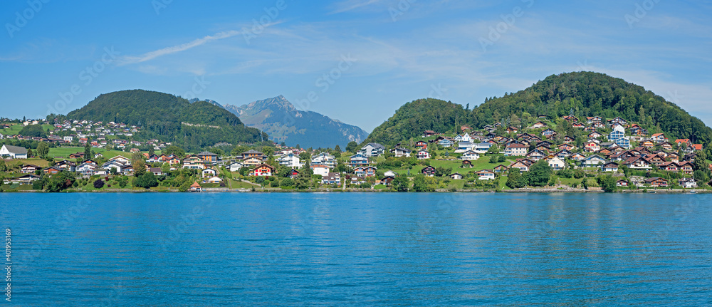 tourist resort Faulensee, at the lakeside of Thunersee, view from a boat, landscape panorama switzerland