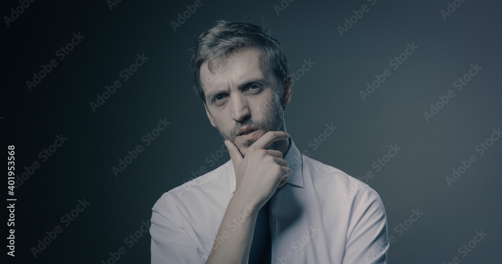 Pensive man thinking with hand on chin Pensive man thinking with hand on chin