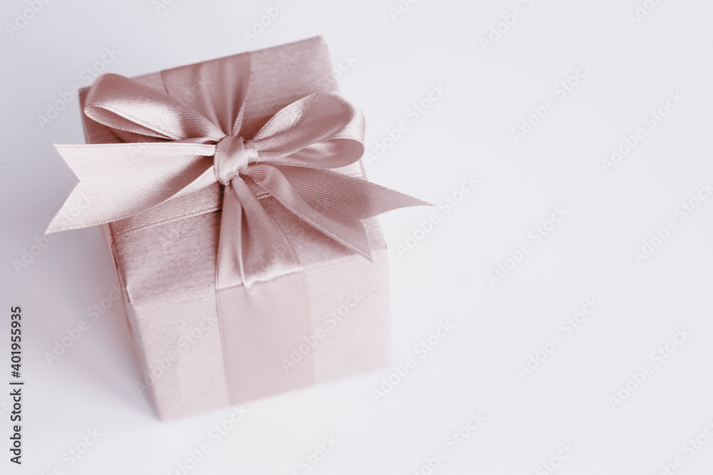 Obraz premium Brown paper gift box with beautiful satin ribbon, monochrome toned design, pastel colors. Universal gifts design for all kind of shopping and celebration