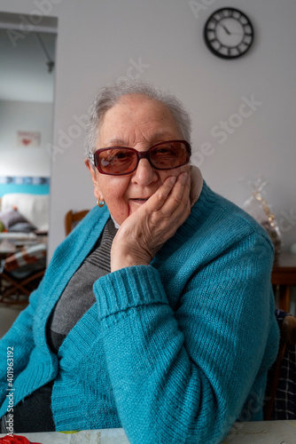 grand mere souriante, assise à table photo